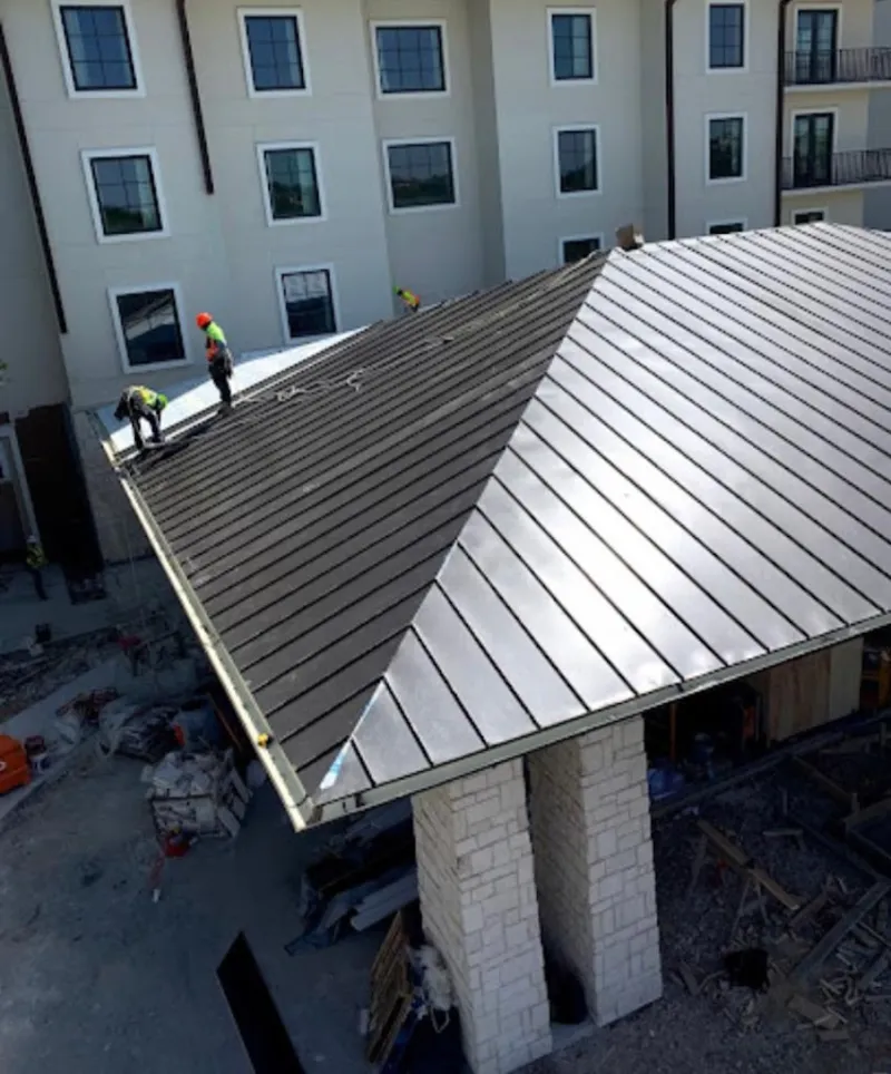 Crew installing standing seam metal roof panels on a commercial project in Southwest Ranches